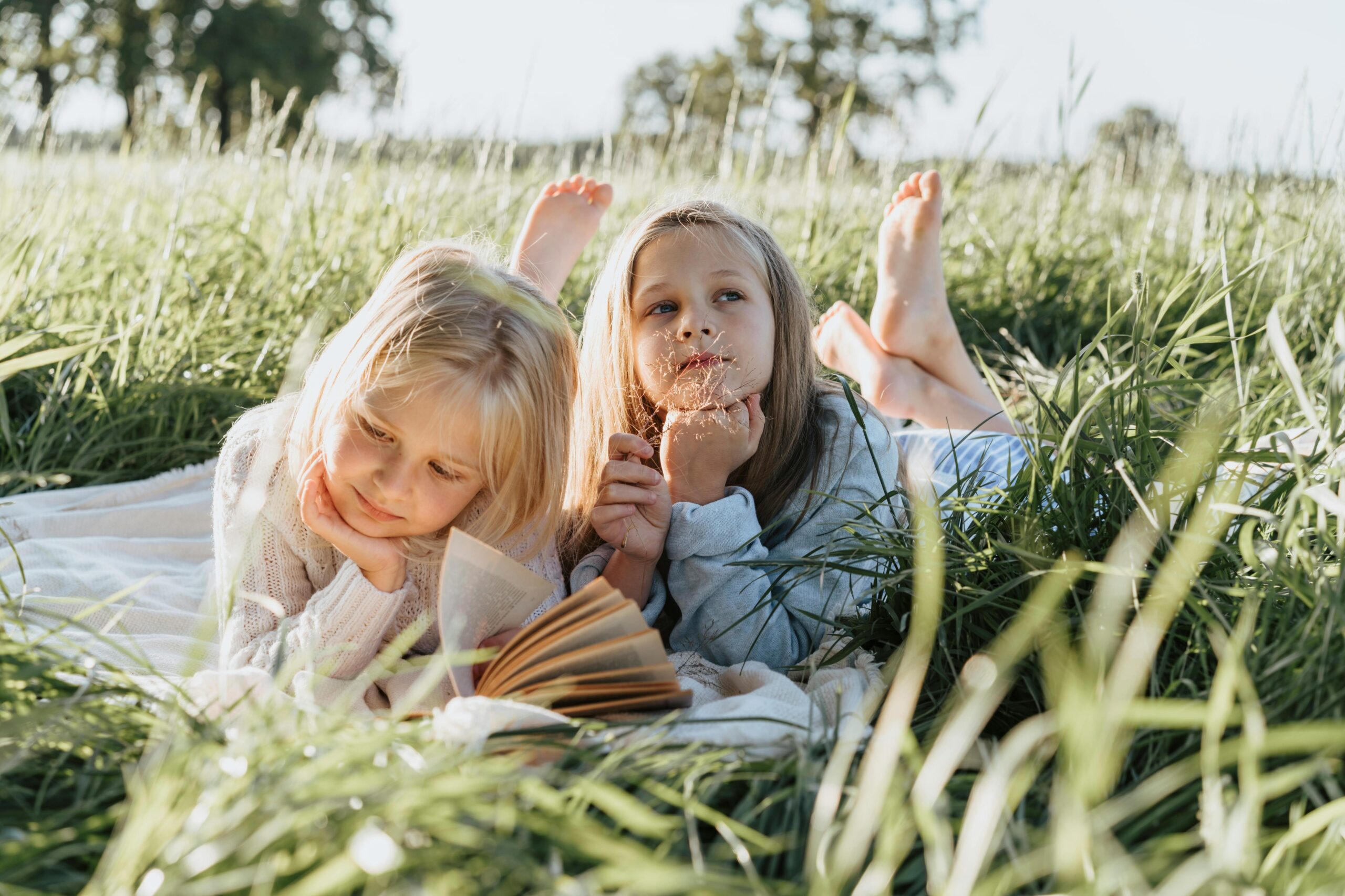 two girls in laying in grass